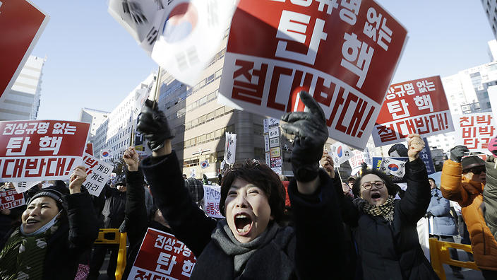 Protesters supporting South Korean President Park Geun-hye shout slogans during a rally opposing the impeachment of South Korean President Park Geun-hye in front of the ruling Saenuri Party headquarters in Seoul, South Korea, Tuesday, Dec. 6, 2016. South Korea is entering potentially one of the most momentous weeks in its recent political history, with impeachment looming for Park as ruling party dissenters align with the opposition in a strengthening effort to force her out. The letters read "Oppose the impeachment. " (AP Photo/Ahn Young-joon)