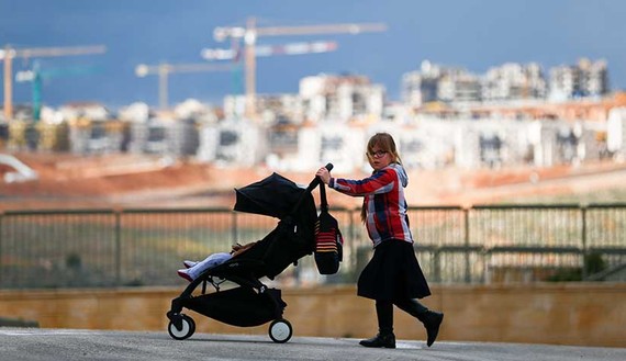 A girl pushes a stroller on a road in the Israeli settlement of Beitar Illit in the occupied West Bank February 15, 2017. REUTERS/Amir Cohen TPX IMAGES OF THE DAY - RTSYS6S