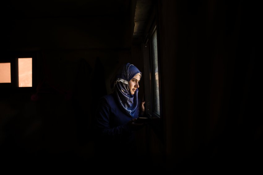 Portrait of Tabarak Karakouz, a 21 years old Syrian refugee, inside her home outskirts Tripoli. Lebanon. She got married 3 years ago. Her husband is in Germany. Her daughter died. She spends all the day watching old pictures and dreaming with a better life with her husband in Europe. July 2017. Diego Ibarra Sánchez / MeMo for DER SPIEGEL