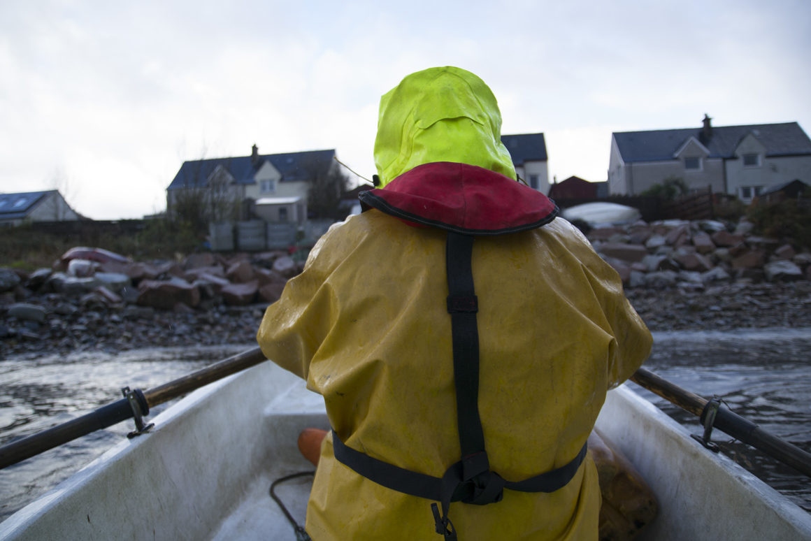 Skipper Lewis MacMillan rows out to his boat the Guess Again in Loch Fyne where he catches prawns | Kait Bolongaro/POLITICO