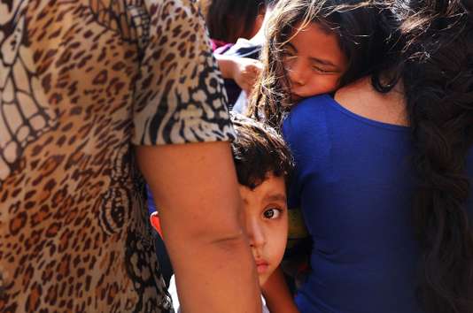 MCALLEN, TX - JUNE 23: Dozens of women, men and their children, many fleeing poverty and violence in Honduras, Guatamala and El Salvador, arrive at a bus station following release from Customs and Border Protection on June 23, 2018 in McAllen, Texas. Once families and individuals are released and given a court hearing date they are brought to the Catholic Charities Humanitarian Respite Center to rest, clean up, enjoy a meal and to get guidance to their next destination. Before President Donald Trump signed an executive order Wednesday that halts the practice of separating families who are seeking asylum, over 2,300 immigrant children had been separated from their parents in the zero-tolerance policy for border crossers Spencer Platt/Getty Images/AFP == FOR NEWSPAPERS, INTERNET, TELCOS & TELEVISION USE ONLY ==