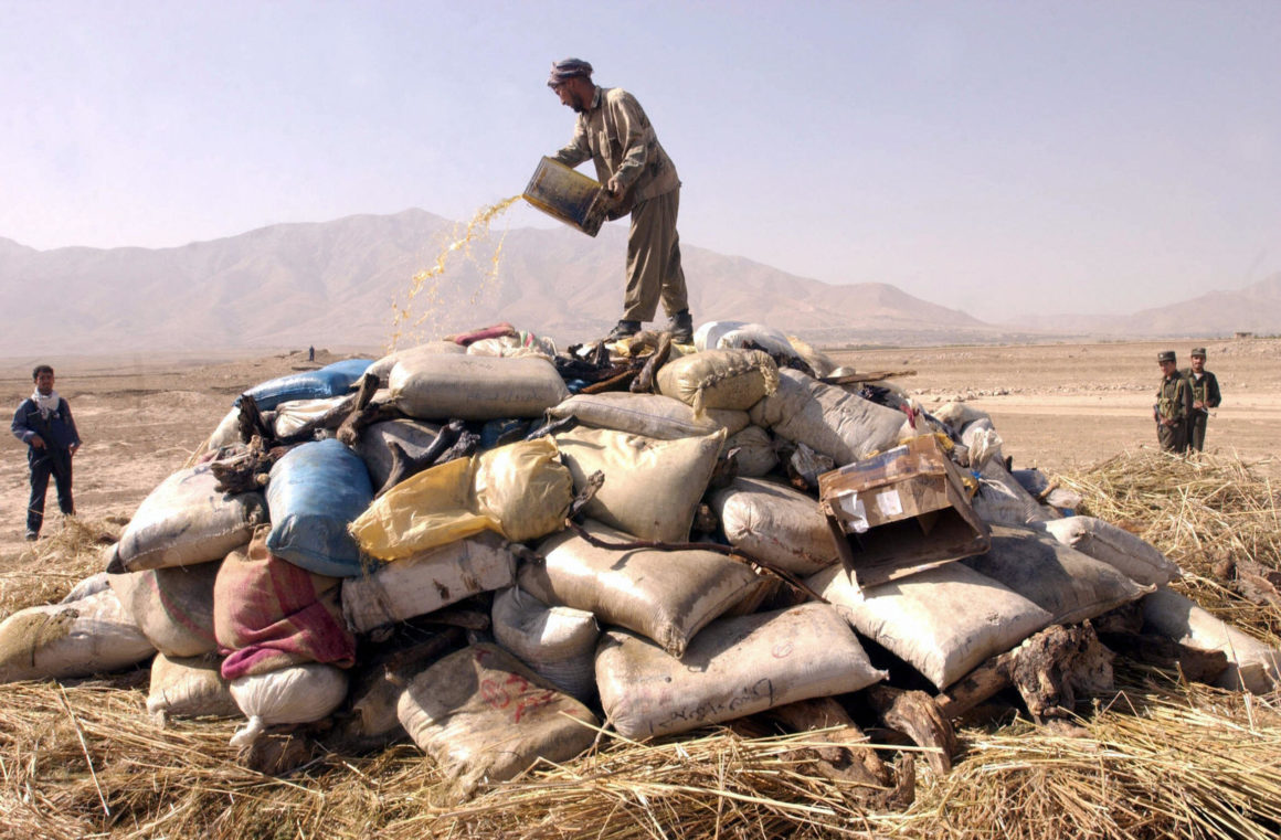 KABUL, AFGHANISTAN: An Afghan man pours petrol onto a pile of seized drugs, including more than 2,5 tons of opium, more than 4 tons of hasish, and some 169 kilos of heroin, before incinerating it outside Kabul, 23 September 2004. Since the fall of the hardline Islamic Taliban regime in late 2001, Afghanistan has become one of the world's biggest drug producers. AFP PHOTO/ Shah Marai (Photo credit should read SHAH MARAI/AFP/Getty Images)