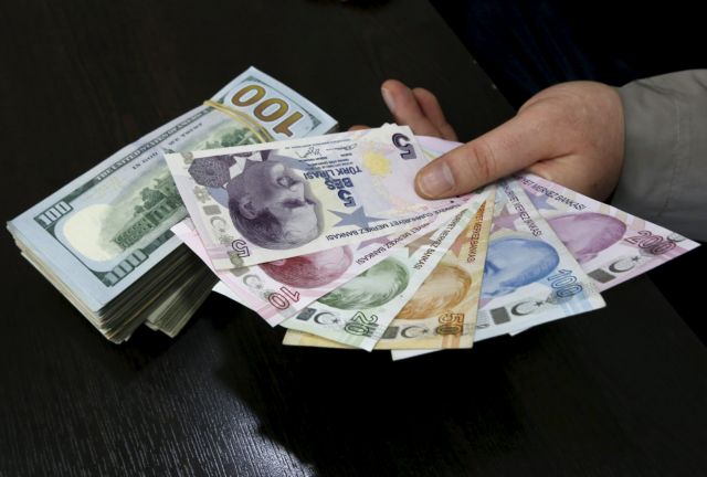 A money changer holds Turkish lira banknotes next to U.S. dollar bills at a currency exchange office in central Istanbul April 15, 2015. Turkish Economy Minister Nihat Zeybekci said on Wednesday the lira's slide to record lows was not a cause for concern and reflected global developments, arguing against forex intervention and saying the currency will find its own balance. He also told a meeting in Istanbul that he expected first quarter year-on-year growth of around 1.5 percent, and full year growth exceeding last year's 2.9 percent. REUTERS/Murad Sezer