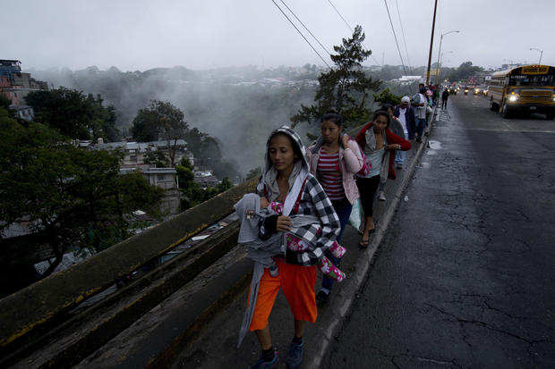 Honduran migrants leave Guatemala City at sunrise Thursday, Oct. 18, 2018 as they make continue their way north toward the U.S. Many of the more than 2,000 Hondurans in a migrant caravan trying to wend its way to the United States left spontaneously with little more than the clothes on their backs and what they could quickly throw into backpacks. (AP Photo/Moises Castillo)